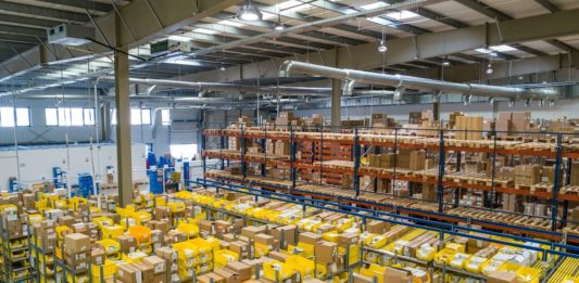 Umělá inteligence v logistice: zadavatelé a 3PL ji využívají jinak Distribuční sklad s regály a žlutými přepravkami se zbožím