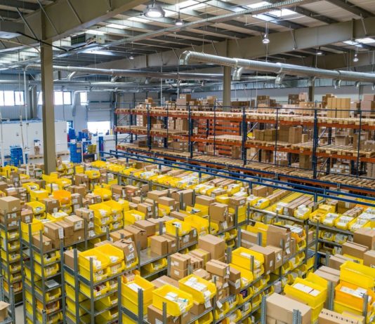 Umělá inteligence v logistice: zadavatelé a 3PL ji využívají jinak Distribuční sklad s regály a žlutými přepravkami se zbožím