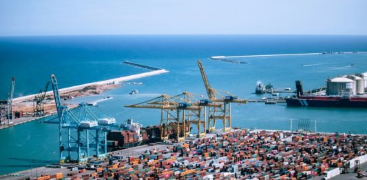 Geopolitika a AI vedou žebříček trendů dodavatelských řetězců 2027 Letecký pohled na kontejnerový terminál s jeřáby a námořním přístavem