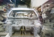 Audi v Ingolstadtu zkouší humanoidní roboty na řazení dílů k montáži Karoserie automobilu na montážní lince obklopená průmyslovými roboty