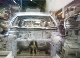 Audi v Ingolstadtu zkouší humanoidní roboty na řazení dílů k montáži Karoserie automobilu na montážní lince obklopená průmyslovými roboty