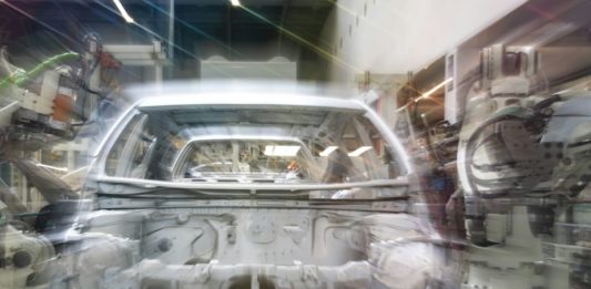 Audi v Ingolstadtu zkouší humanoidní roboty na řazení dílů k montáži Karoserie automobilu na montážní lince obklopená průmyslovými roboty