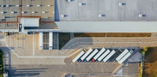 DHL vloží do střední a východní Evropy přes 400 milionů eur Letecký pohled na logistické centrum s nákladními návěsy u nakládacích ramp a parkovištěm