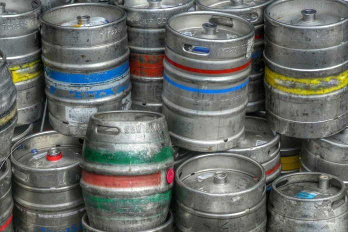 Kovové sudy na pivo naskládané na sobě