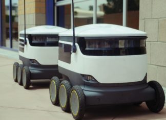 Téměř polovina profesionálních robotů míří do logistiky Dva autonomní doručovací roboti stojí na chodníku u budovy