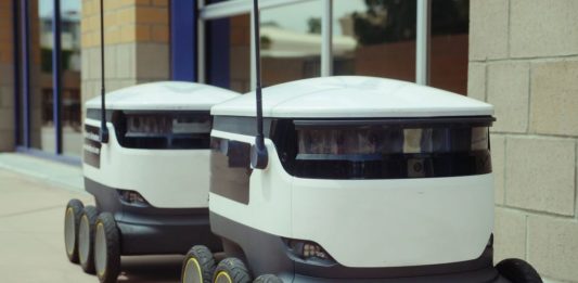 Téměř polovina profesionálních robotů míří do logistiky Dva autonomní doručovací roboti stojí na chodníku u budovy