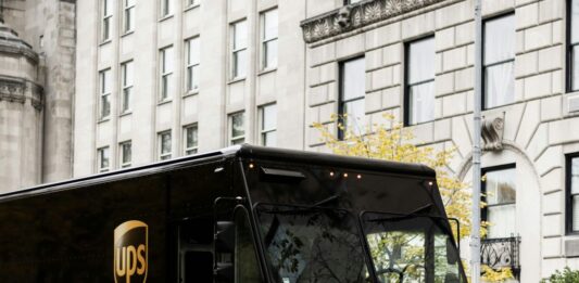 UPS zvedá celoroční výhled, tržby ve třetím čtvrtletí rostly o 6,7 % Hnědý doručovací vůz UPS v ulici města