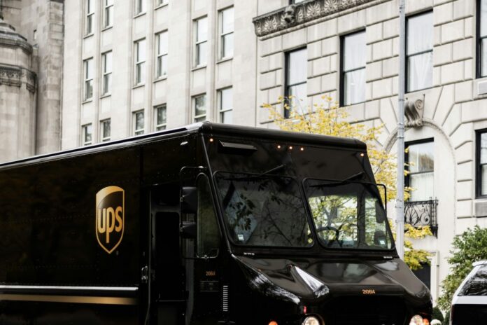 UPS zvedá celoroční výhled, tržby ve třetím čtvrtletí rostly o 6,7 % Hnědý doručovací vůz UPS v ulici města